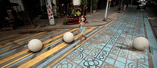 A pedestrian walking on blue and yellow painted concrete