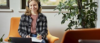 Student sitting in front of laptop focusing on her online lecture