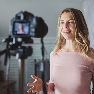 A woman speaks into a camera and answers questions.